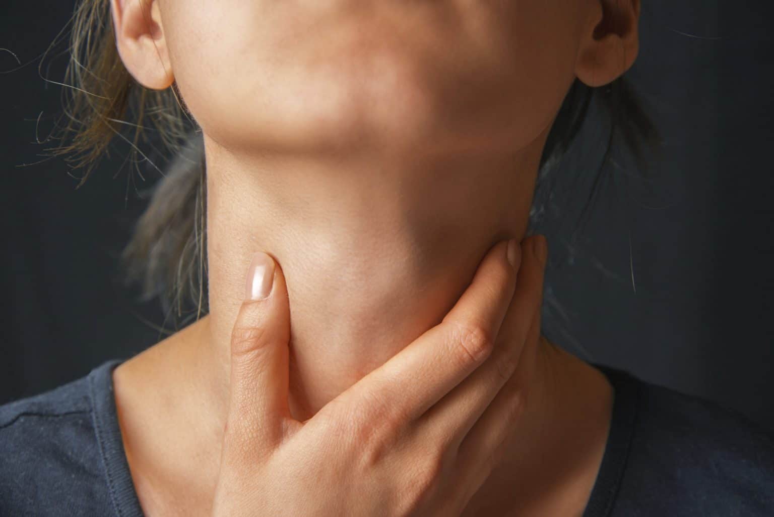 Swallowing-Disorders-exam Woman with hand on throat assessing her swallowing disorder.